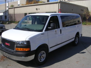 Image of the white fleet passenger van's left side, shot from the front.