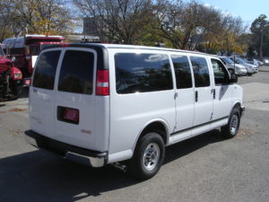 Image of the white fleet passenger van's right side, shot from behind.