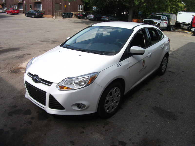 Image of the white fleet car's left side, shot from the front.