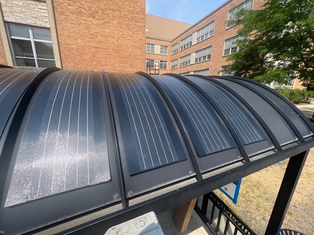 Photo of curved solar panels installed on top of the bus shelter at Randall and Engineering Drive.